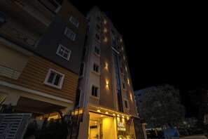 Ein mehrgeschossiges Gebäude mit beleuchteter Beschilderung für 'TOWNHOUSE DAK' und 'OAK BUSINESS HOTELS'.