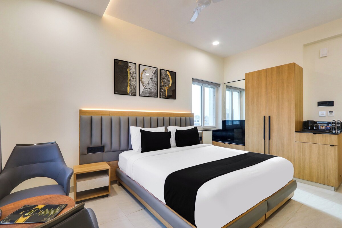 Ein modernes Hotelzimmer mit Bett, Sitzecke, Fernseher und Kleiderschrank.