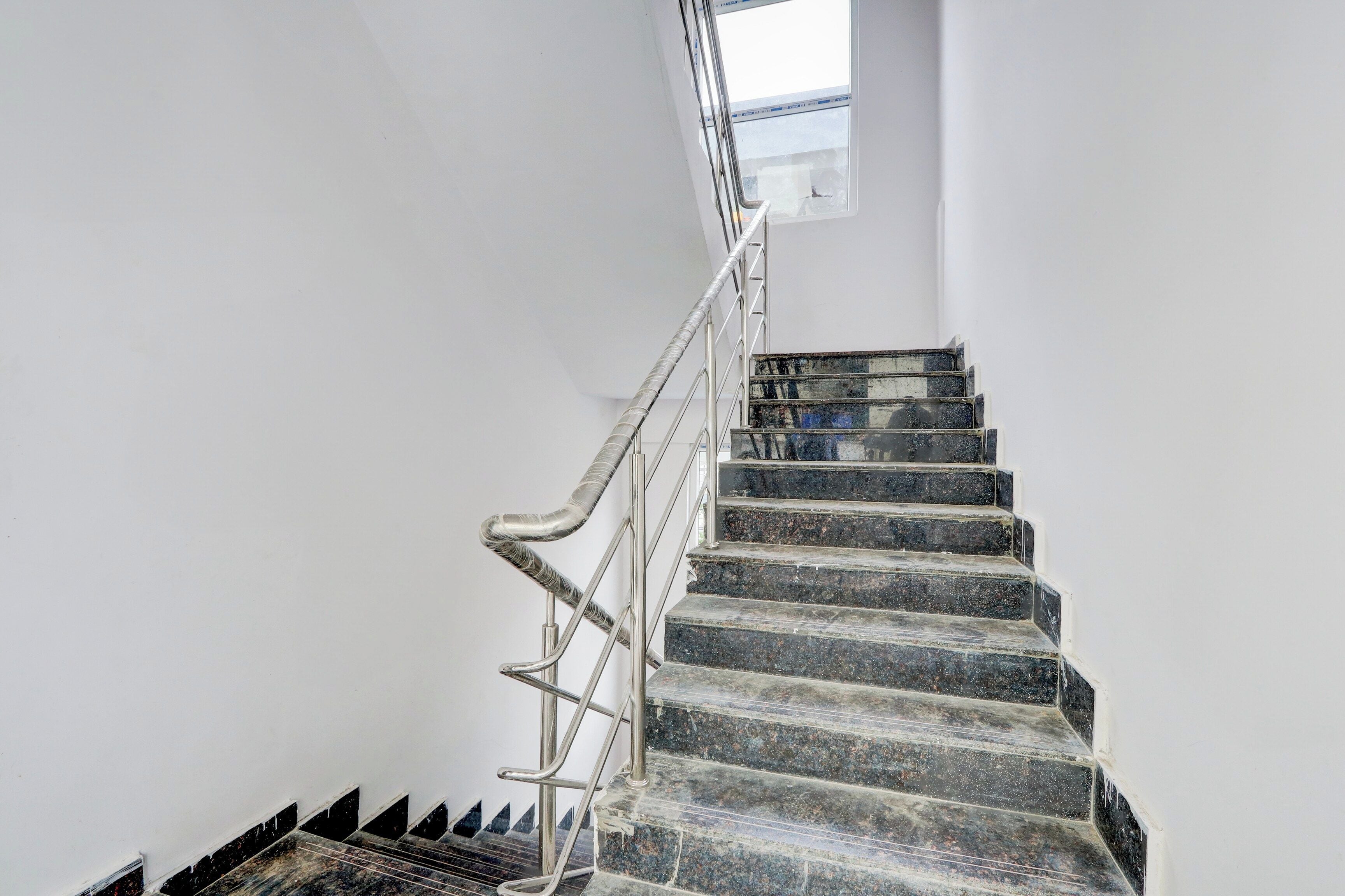 A staircase with metal railings and a skylight above.