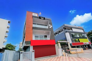 A hotel with a red facade, a sign indicating it's a hotel, and a visible entrance. - Hotel O by OYO Living Tree In (Hyderabad)