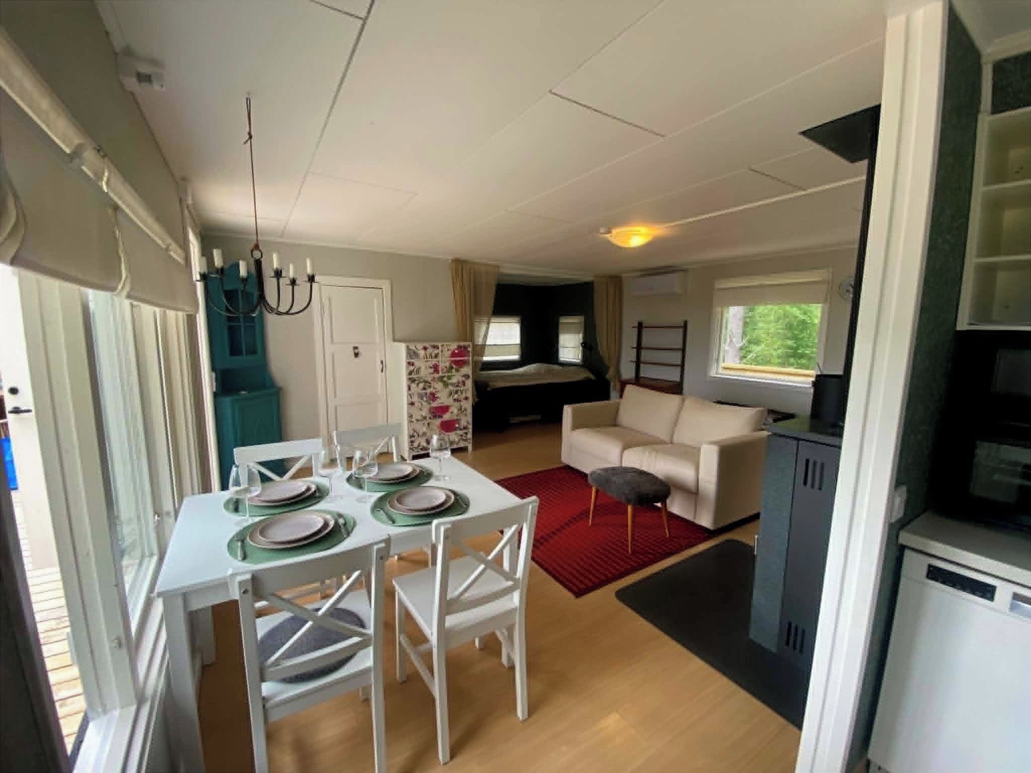 Un espacio habitable compacto con comedor, sofá y kitchenette.