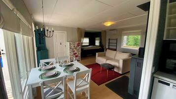 Un espacio habitable compacto con comedor, sofá y kitchenette.