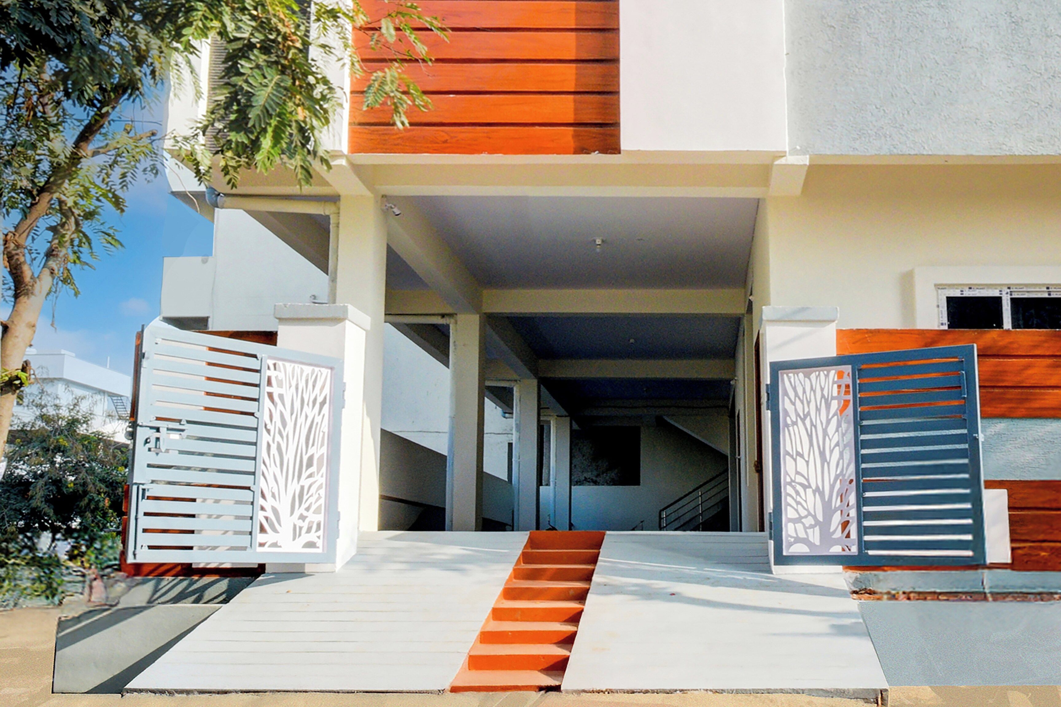 A modern building with a covered entrance, a staircase, and a clear sky.