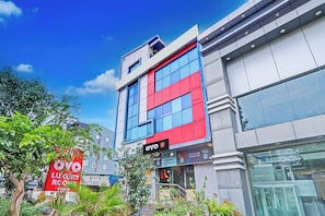 A modern building with a prominent 'OYO' sign, indicating a hotel or lodging facility. - Hotel O by OYO M&N Grand (Hyderabad)