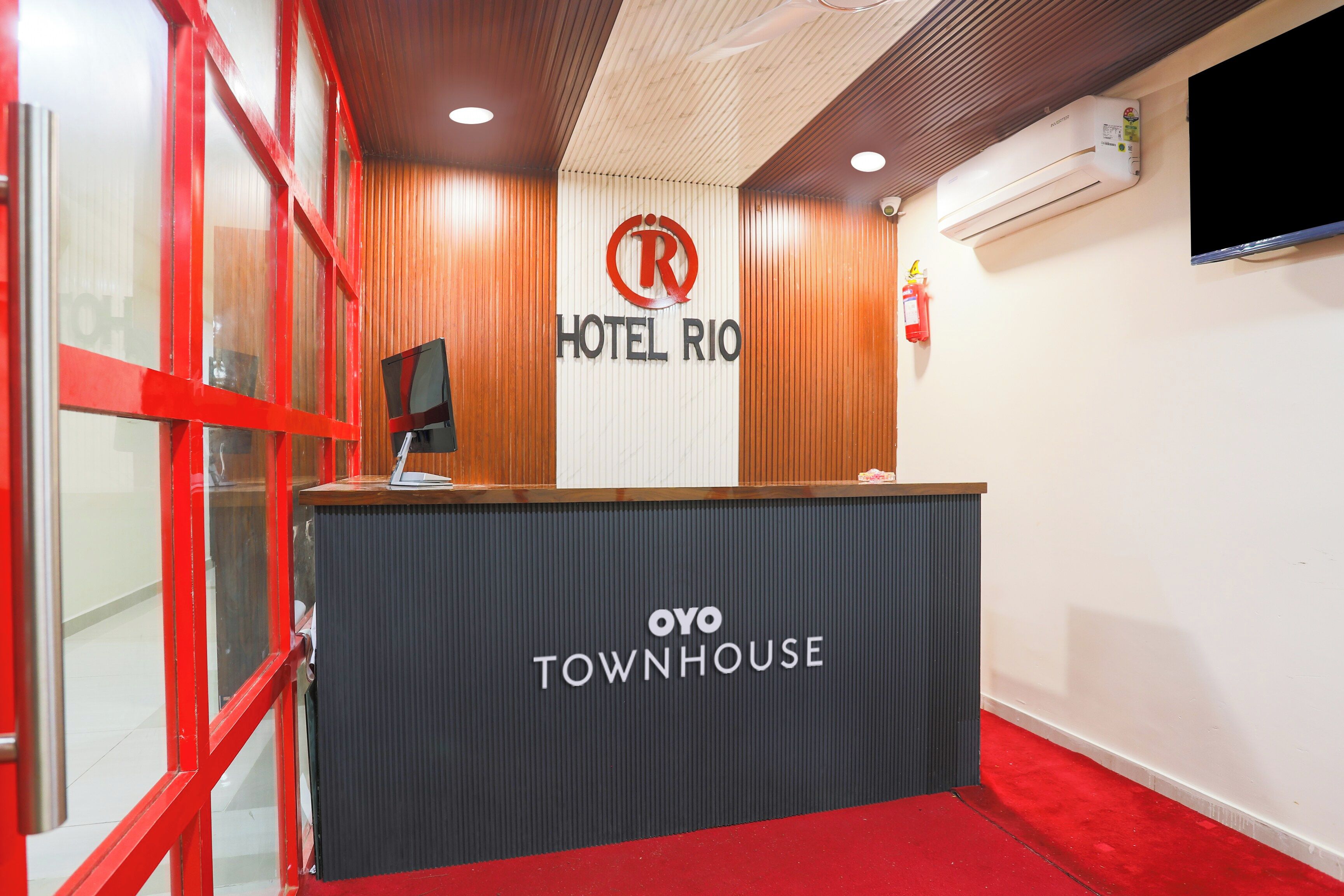 A reception desk with a sign for 'Hotel Rio' and 'Oyo Townhouse.'