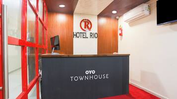 A reception desk with a sign for 'Hotel Rio' and 'Oyo Townhouse.'