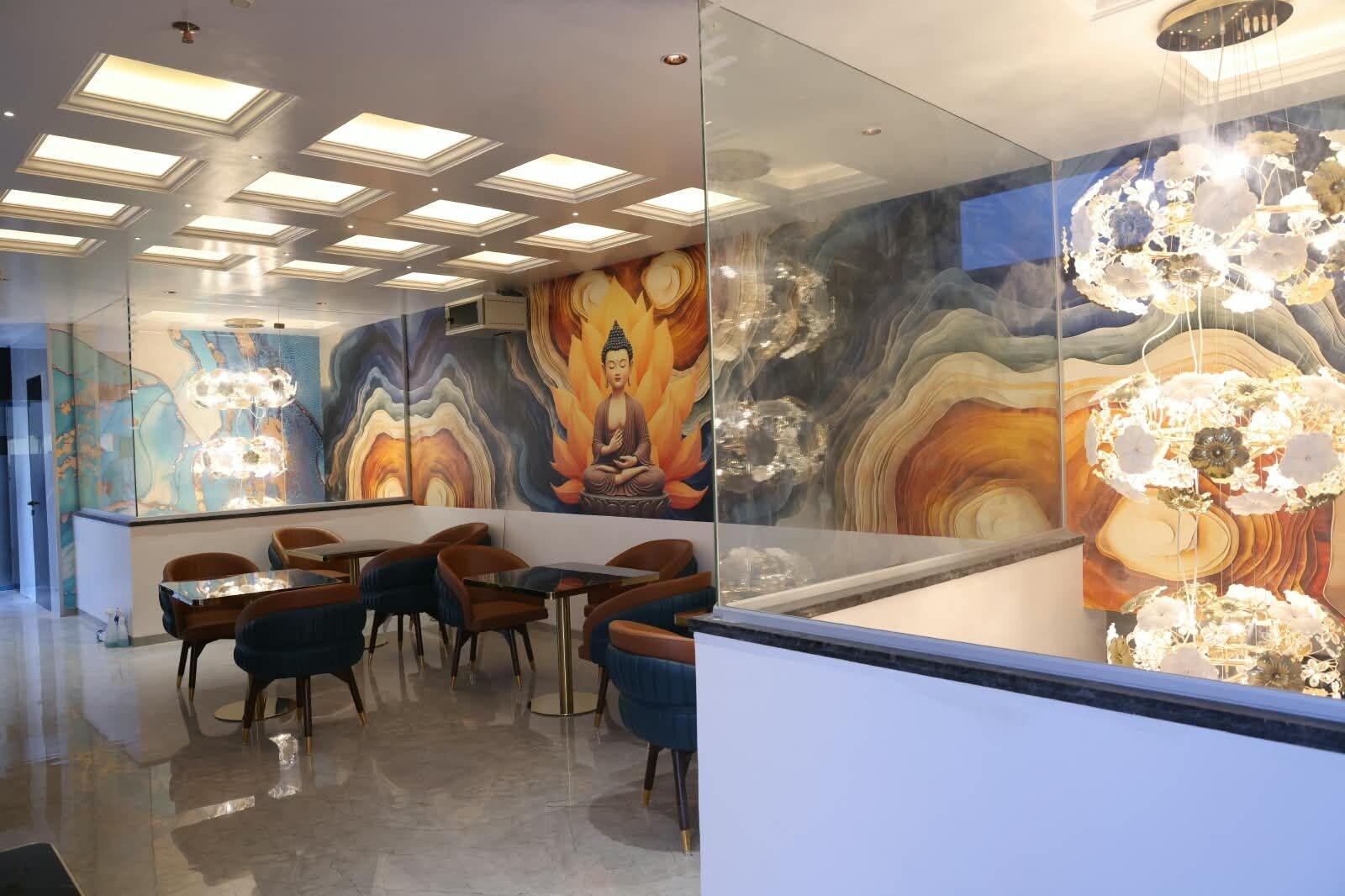 A modern interior with a glass partition, a Buddha statue, and a floral chandelier.
