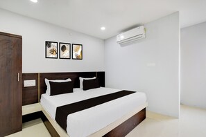 A hotel room with a bed, a wardrobe, an air conditioning unit, and three framed artworks on the wall. - Hotel O RRR Residency & Luxury rooms (Hyderabad)