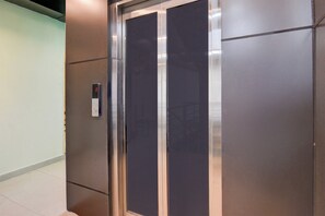 Un ascensor con puertas metálicas y un panel de control.