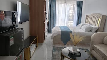 Une chambre d’hôtel équipée d’un lit, d’une télévision, d’un canapé et d’une table basse.
