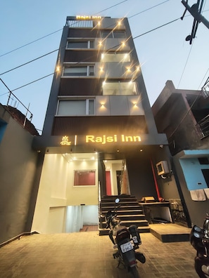 A building with a sign reading 'Rajsi Inn' and a motorcycle parked in front. - Hotel Rajsi Inn (Faizabad)