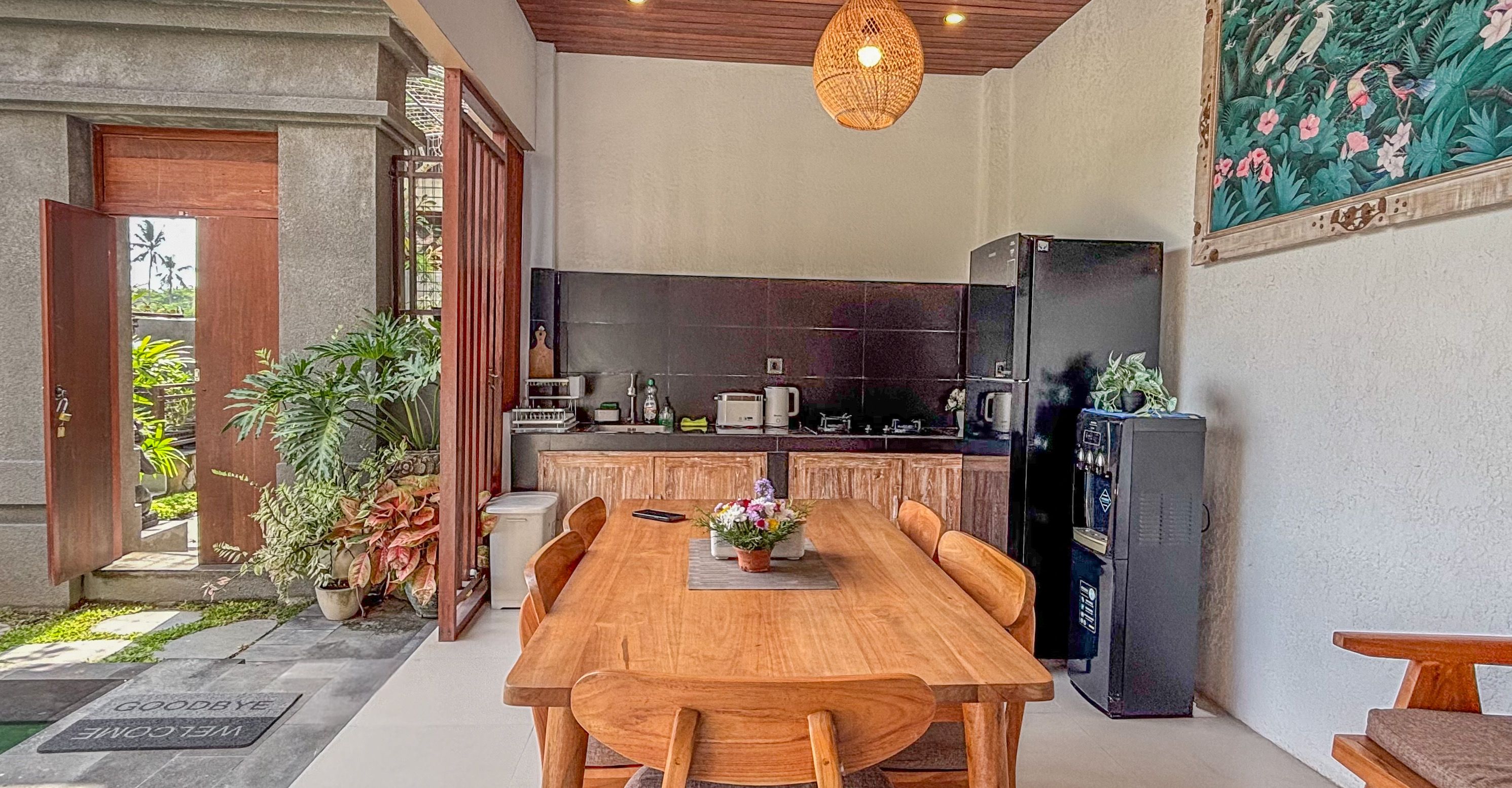 A modern kitchen with a wooden dining table, a black refrigerator, and a tiled backsplash.