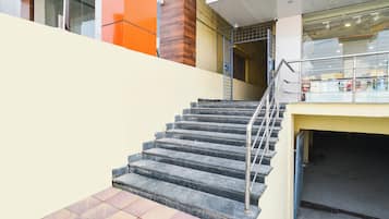 Una escalera con barandillas metálicas que baja a un nivel inferior.