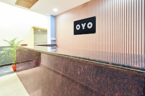 Una mesa de recepción con un letrero que dice 'OYO' sobre un fondo de madera.