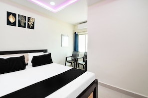 Una habitación de hotel con una cama, un escritorio y sillas.