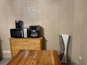 Une petite cuisine équipée d’un four à micro-ondes, d’une machine à café et d’un réfrigérateur.