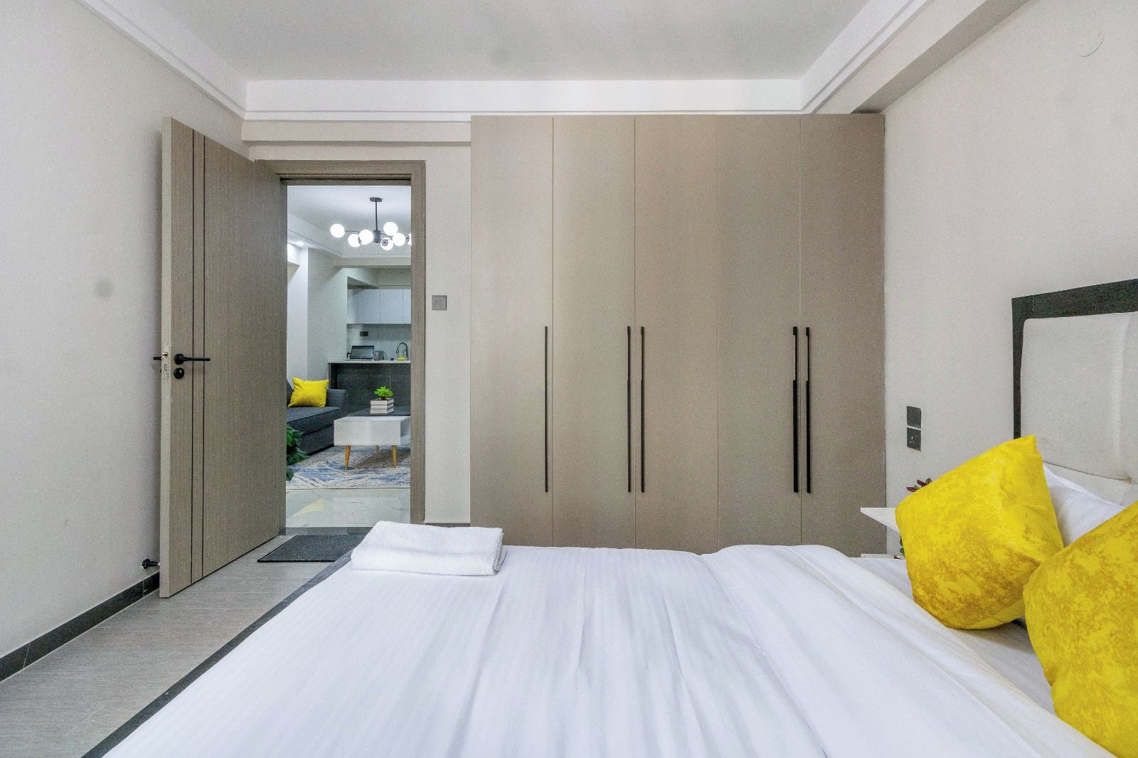 Quarto de hotel com cama, guarda-roupa e vista para a sala de estar.
