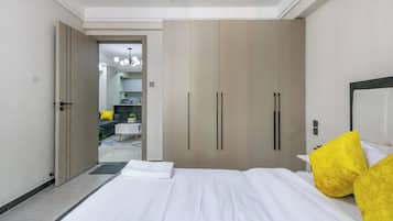 Quarto de hotel com cama, guarda-roupa e vista para a sala de estar.