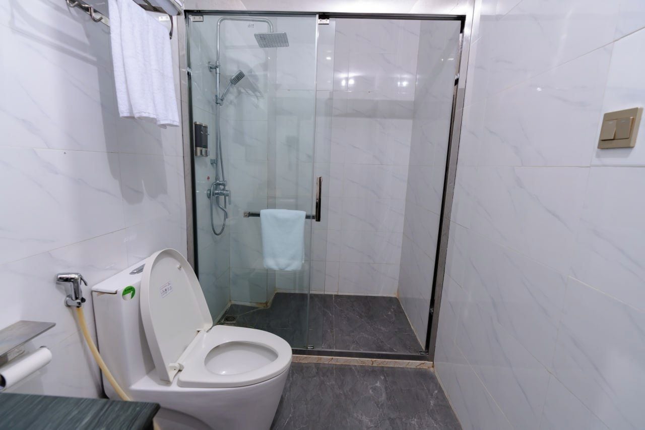 Kylpyhuoneessa on lasiseinällä varustettu suihku, wc ja pyyhekoukku.