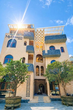 Un hôtel doté d’une entrée centrale, de nombreux balcons et d’une façade géométrique remarquable.
