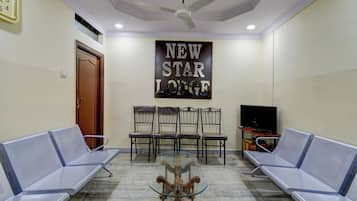 A waiting area with a ceiling fan, a wall-mounted sign reading 'NEW STAR LOUNGE', and two rows of seating.