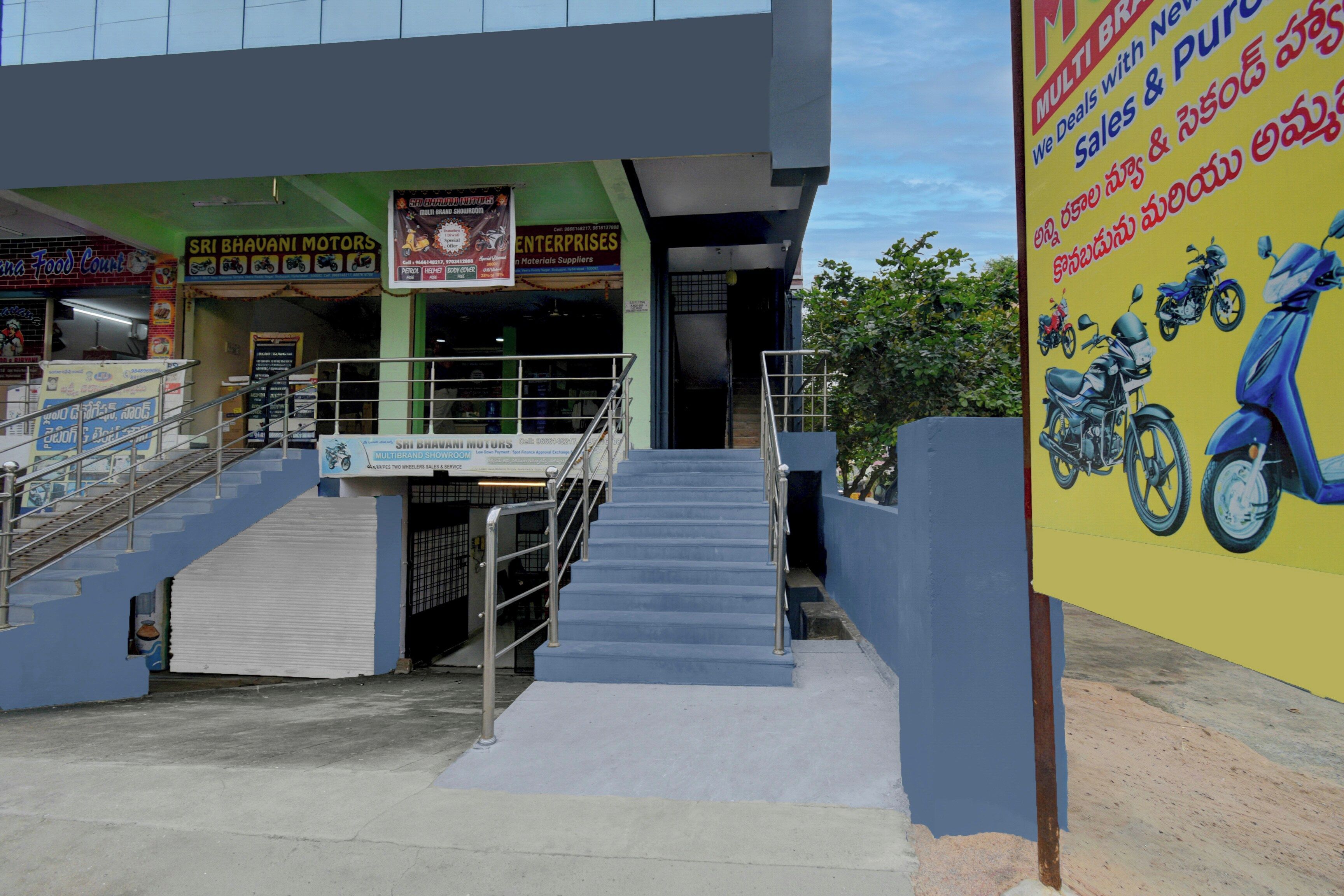 A multi-brand showroom with a staircase leading to the entrance.