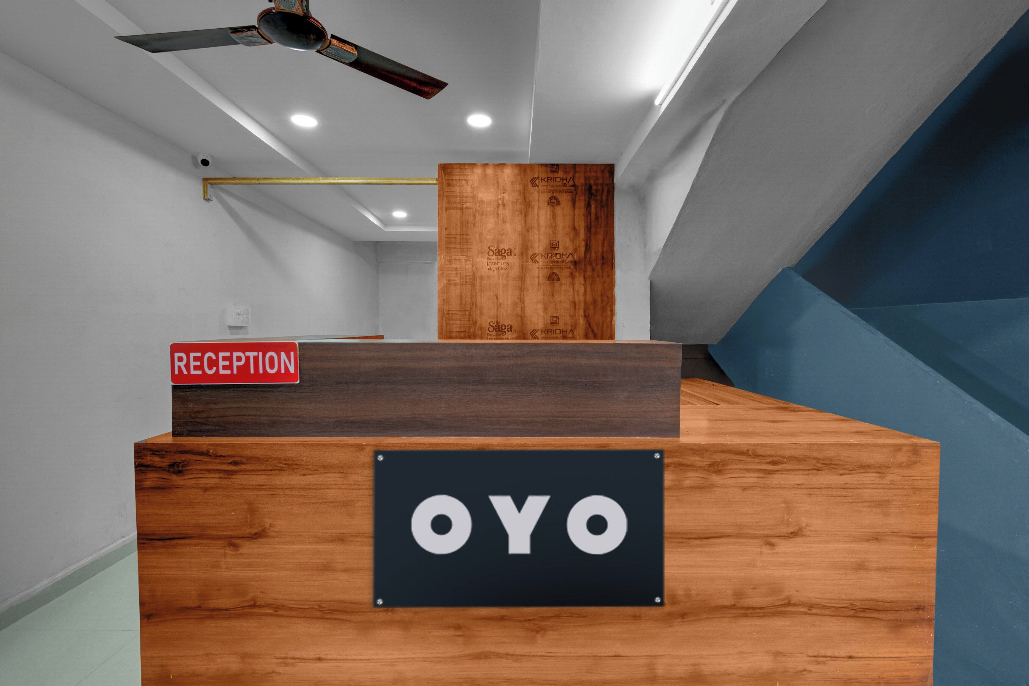 A reception desk with a sign that reads 'RECEPTION' and another sign with 'OYO'.