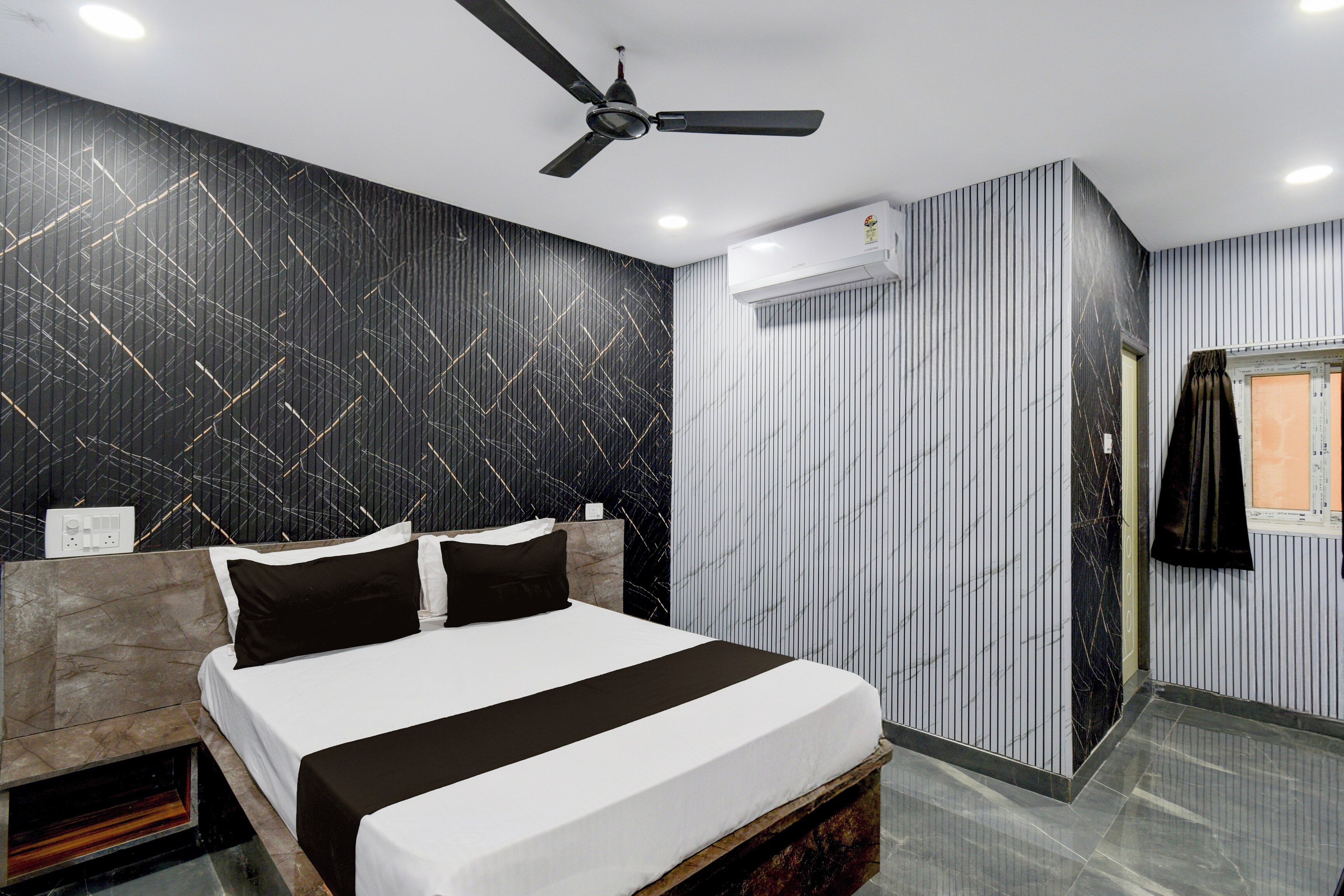 A modern bedroom with a bed, a ceiling fan, and a window with curtains.