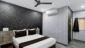 A modern bedroom with a bed, a ceiling fan, and a window with curtains.