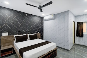 A modern bedroom with a bed, a ceiling fan, and a wall-mounted air conditioner. - Hotel O Nova Comfort Inn (Hyderabad)