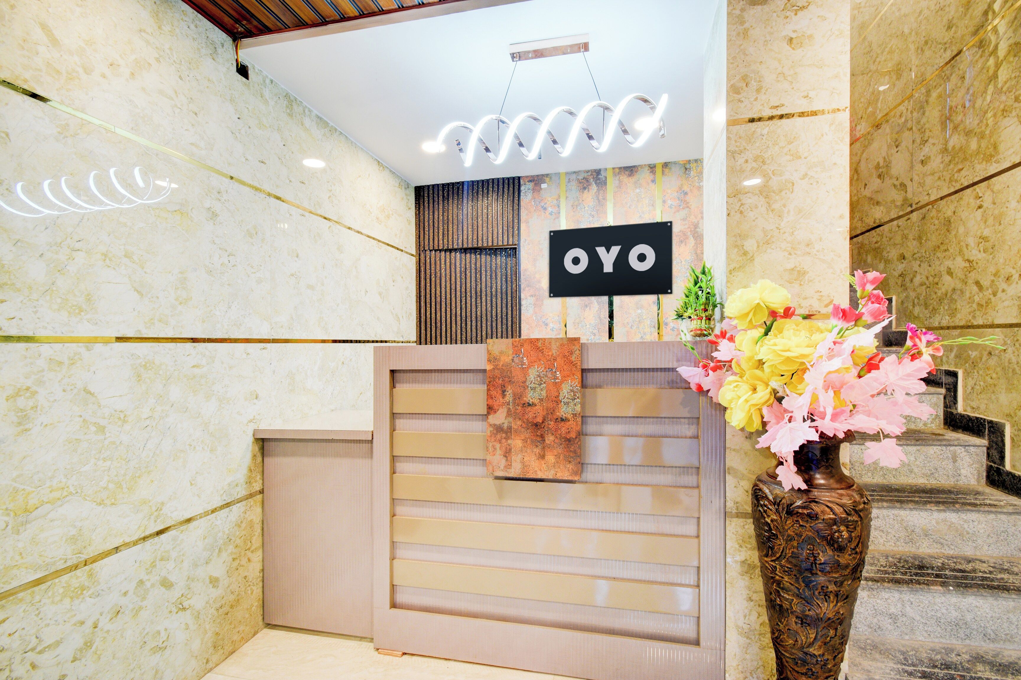 A reception desk with a sign that reads 'OYO' and a vase with flowers.