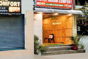 A hotel entrance with a closed shutter on the left and a sign for 'Hotel Indian Comfort' above the door. - Hotel O by OYO Indian Comfort (Hyderabad)