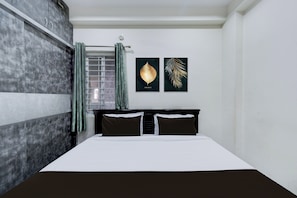 A bedroom with a bed, a window with curtains, and two wall art pieces. - Hotel O RR GRAND STAY (Hyderabad)