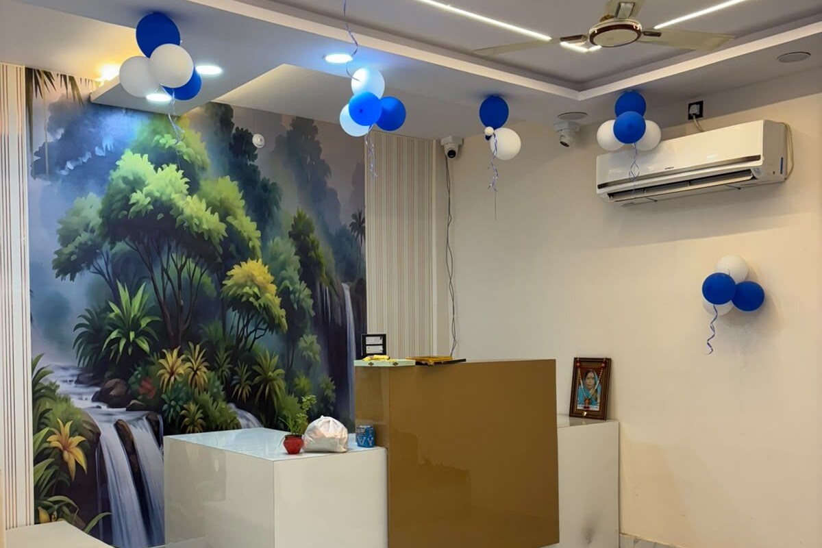 Un área de recepción con un mural, un mostrador de recepción y un ventilador de techo.