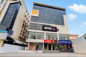 A hotel building with a modern facade, large windows, and signage for OYO Hotel and Centuy mattresses. - Hotel O RB Comfort (Hyderabad)