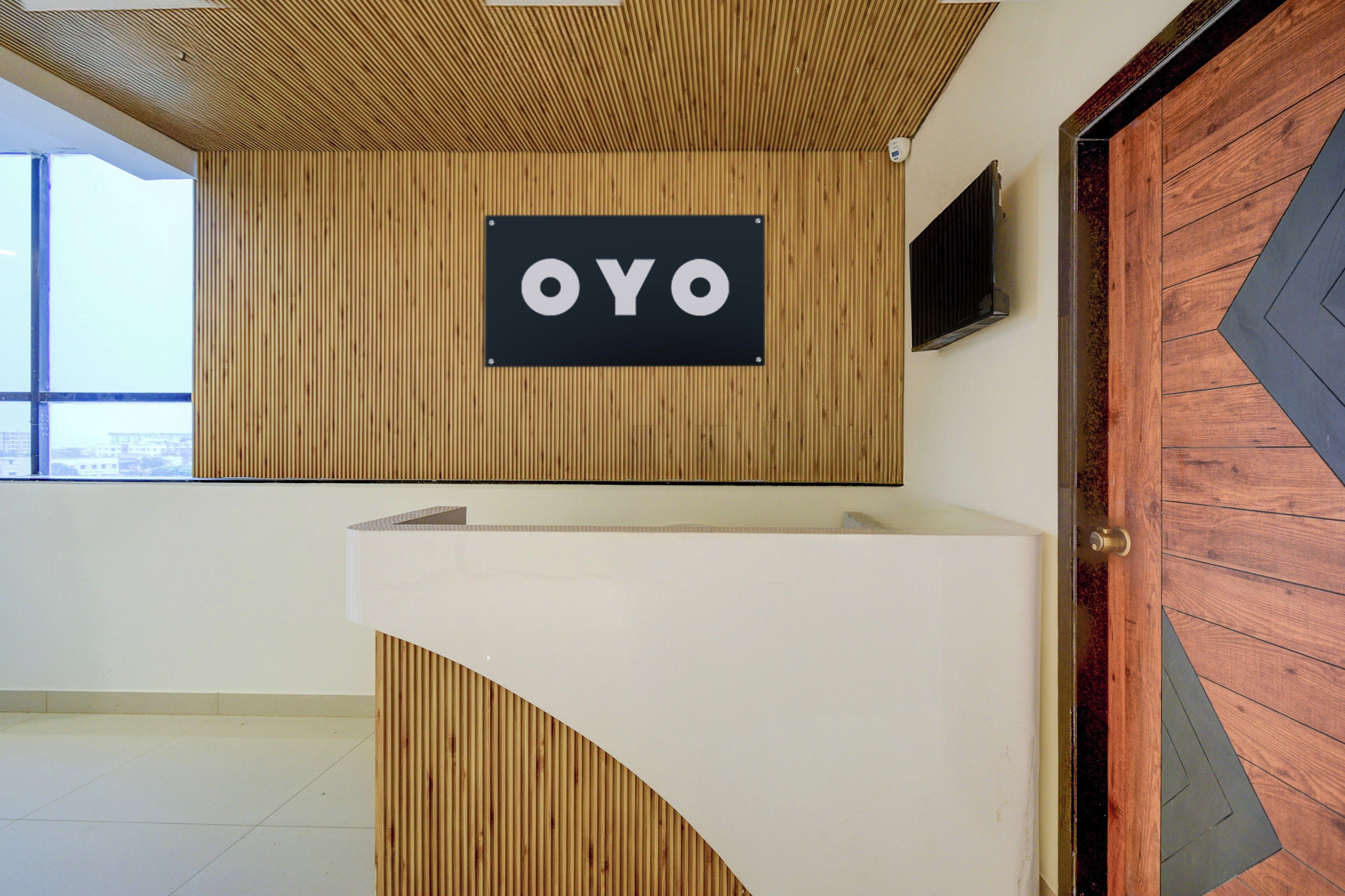 A reception desk with a sign that reads 'OYO' against a wooden wall.