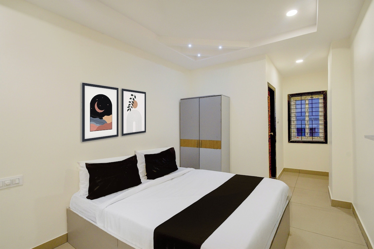 Un dormitorio con una cama, un armario y dos cuadros en la pared.