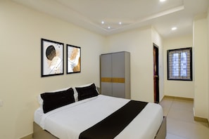 Un dormitorio con cama, armario y dos cuadros en la pared.