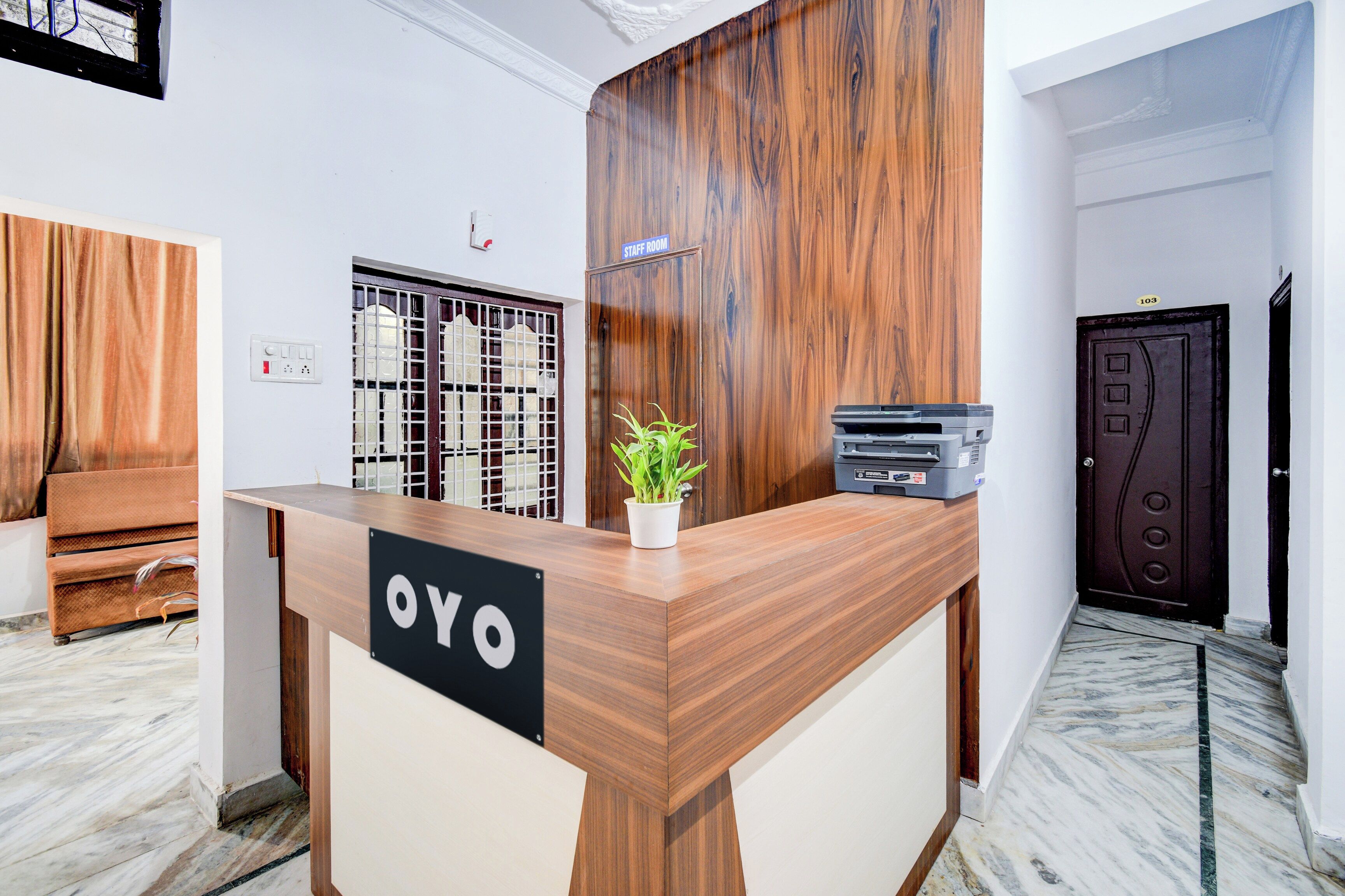 A reception desk with a sign reading 'OYO' in a hotel lobby.