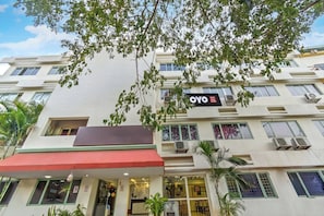 A hotel building with multiple floors, balconies, and air conditioning units. - Hotel O RAGA GRAND HOTEL (Hyderabad)