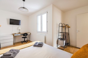 Une chambre d’hôtel équipée d’un lit, d’un bureau, d’une chaise, d’une télévision, d’une fenêtre et d’une armoire.