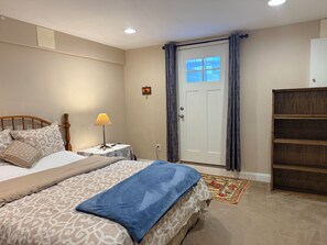 Ein Schlafzimmer mit einem Bett, einem Nachttisch, einer Lampe und einem Kleiderschrank.