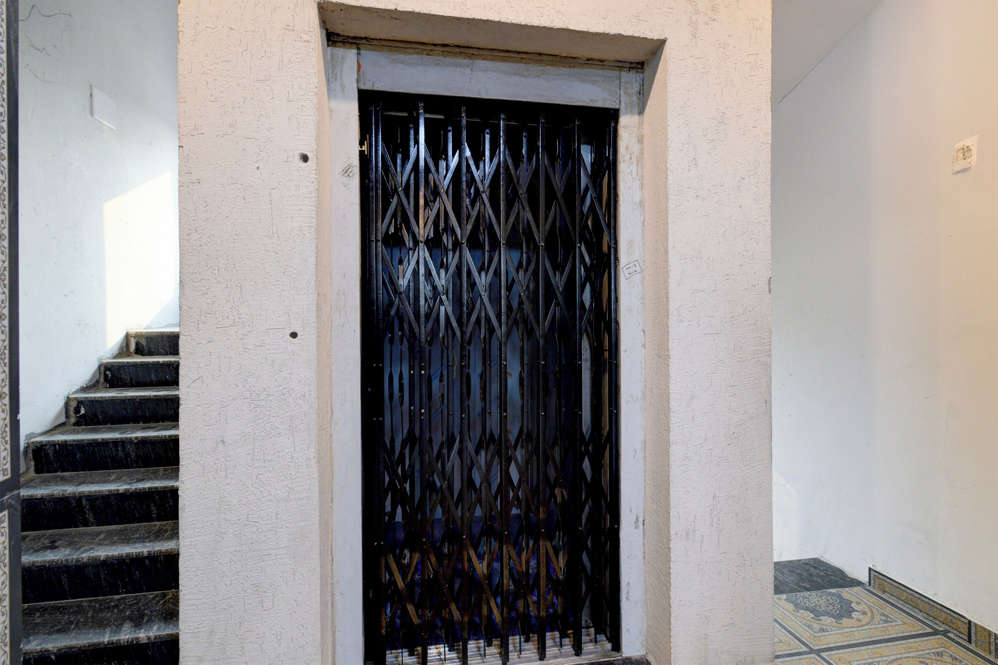 A staircase leading to a door with a metal grille.