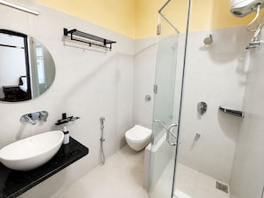 A modern bathroom with a glass-enclosed shower, a white sink, and a mirror. - Hotel R.J. House (Aburaj)