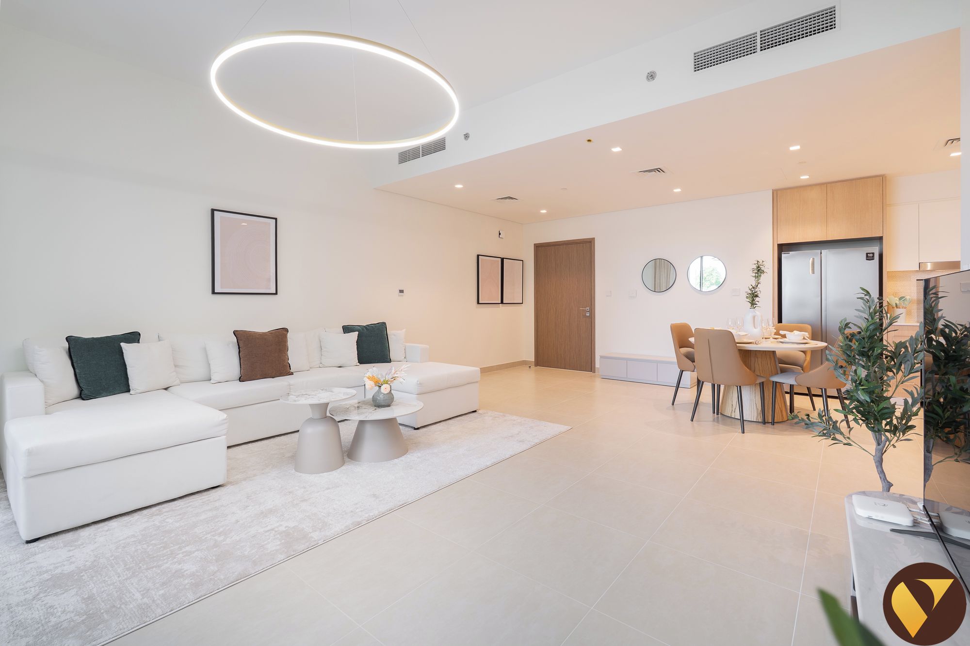 A modern living room with a sofa, coffee table, and dining area with chairs and a table.