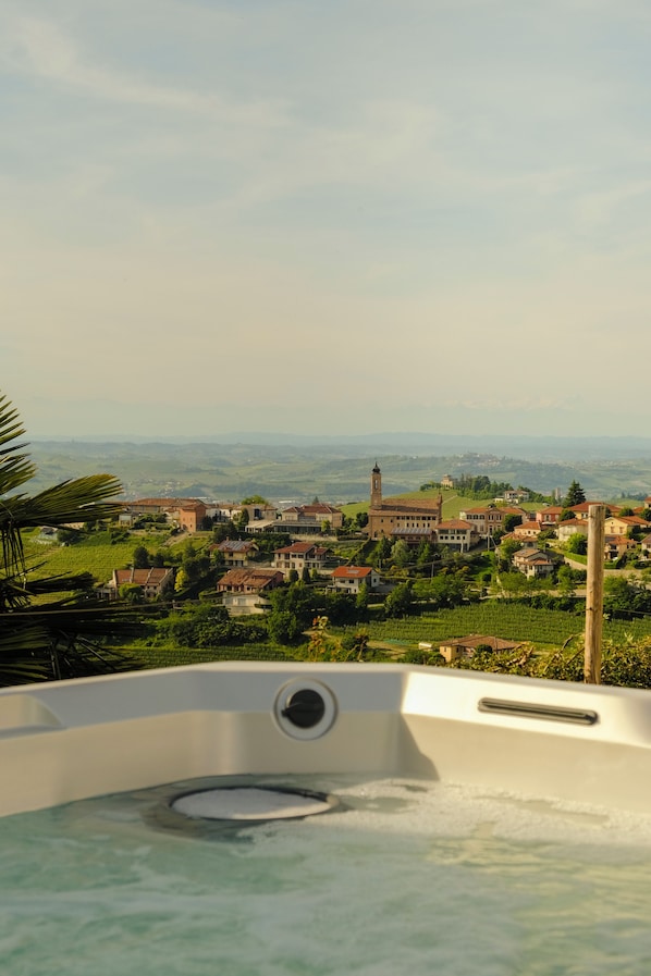 Un bain à remous avec vue sur un village et des montagnes lointaines.