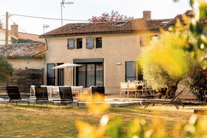 Une maison dotée d’un patio aménagé avec du mobilier d’extérieur et une table à manger.