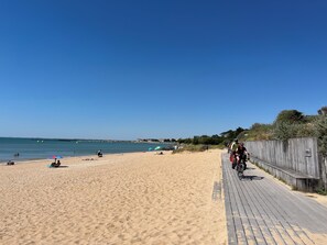 A beach with a wooden boardwalk, clear blue sky, and calm sea. - New Listing (Châtelaillon-Plage)