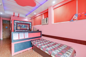 A room with a bed, a desk with a computer, and a wall-mounted air conditioner. - Hotel O Elite Stay Inn (Lucknow)