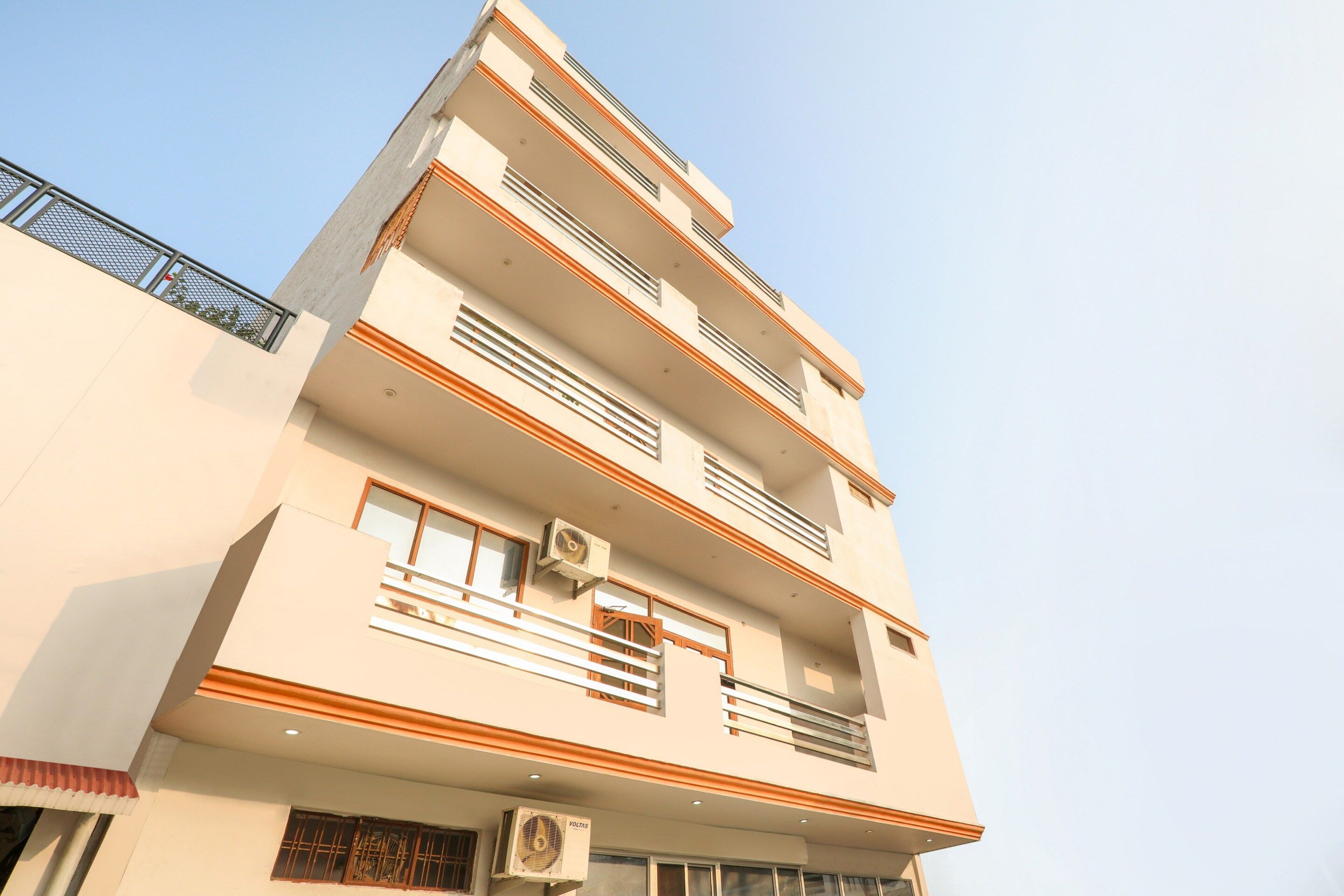 A multi-story building with balconies, windows, and air conditioning units.